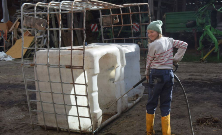 M&auml;dchen reinigt Fass mit einem Hochdruckreiniger