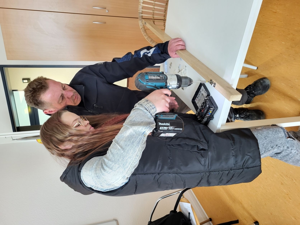 Girls'Day-Teilnehmerinnen mit Mitarbeiter beim Bohren