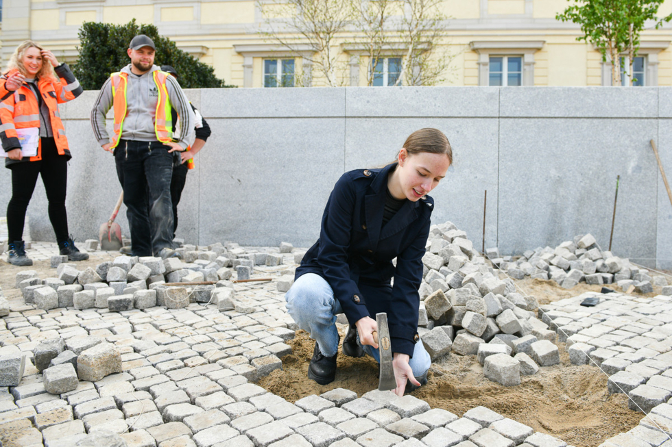 Mädchen im Vordergrund bei Pflaterarbeiten
