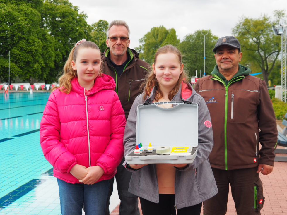 Girls'Day-Teilnehmerinnen mit Personal vor Schwimmbadbecken