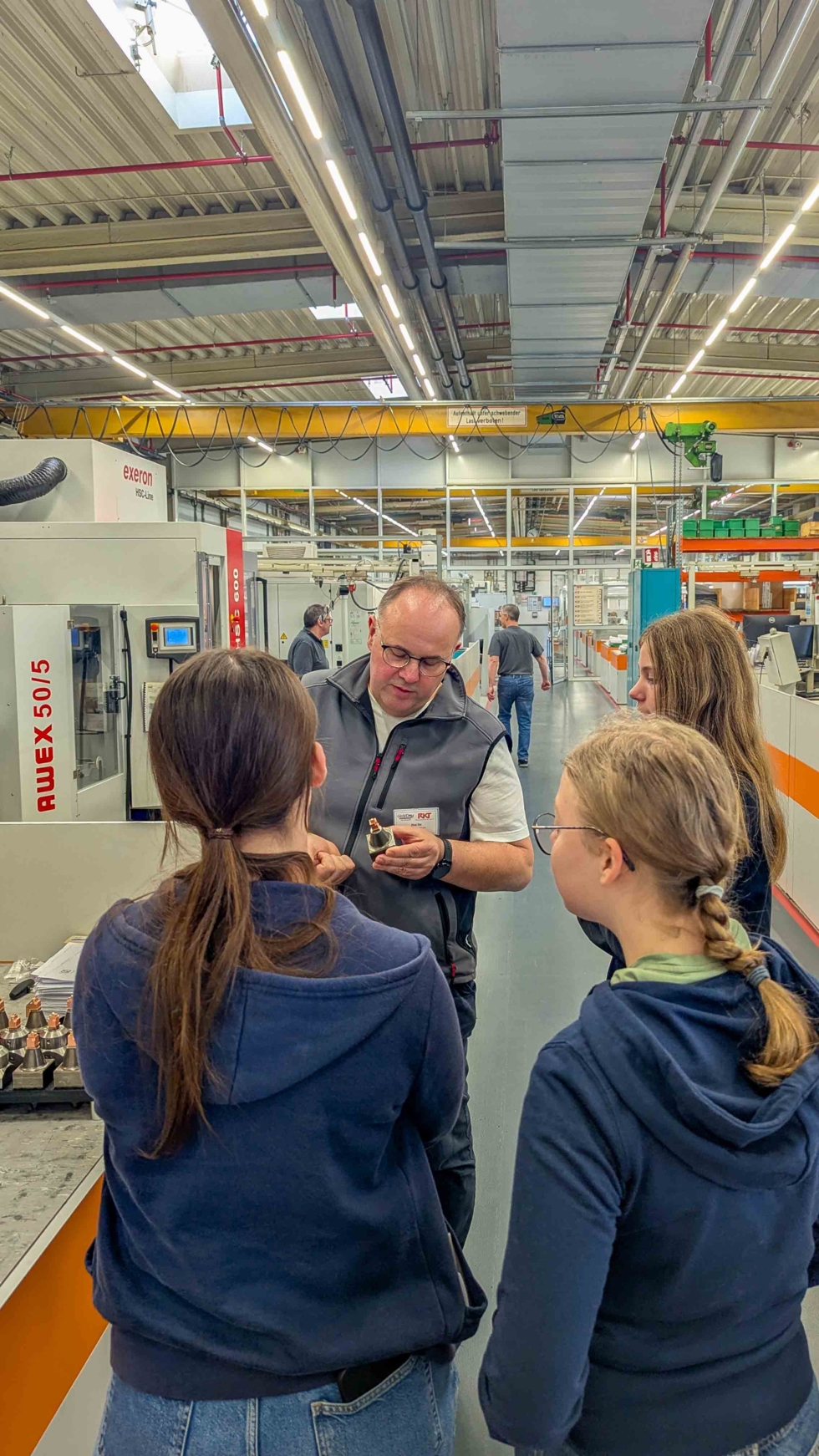 Mitarbeiter zeigt Girls'Day-Teilnehmerinnen technische Teile