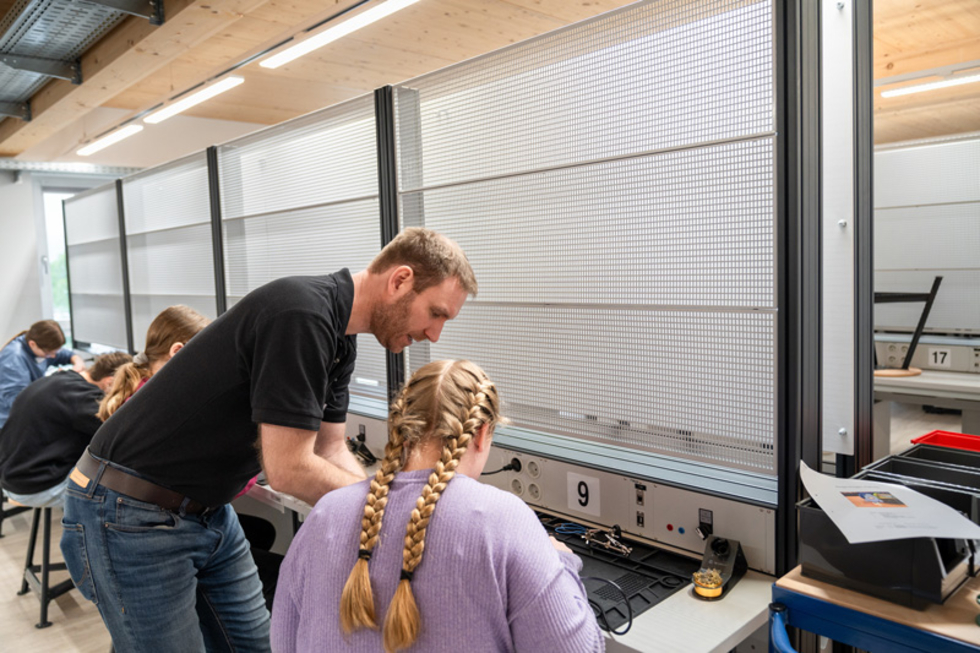 Girls'Day-Teilnehmerin mit Mitarbeiter an Werkbank