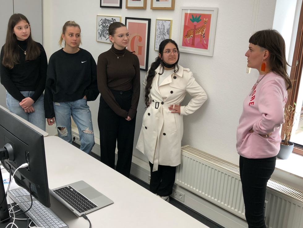 Mehrere junge Frauen stehen um einen Rechner herum
