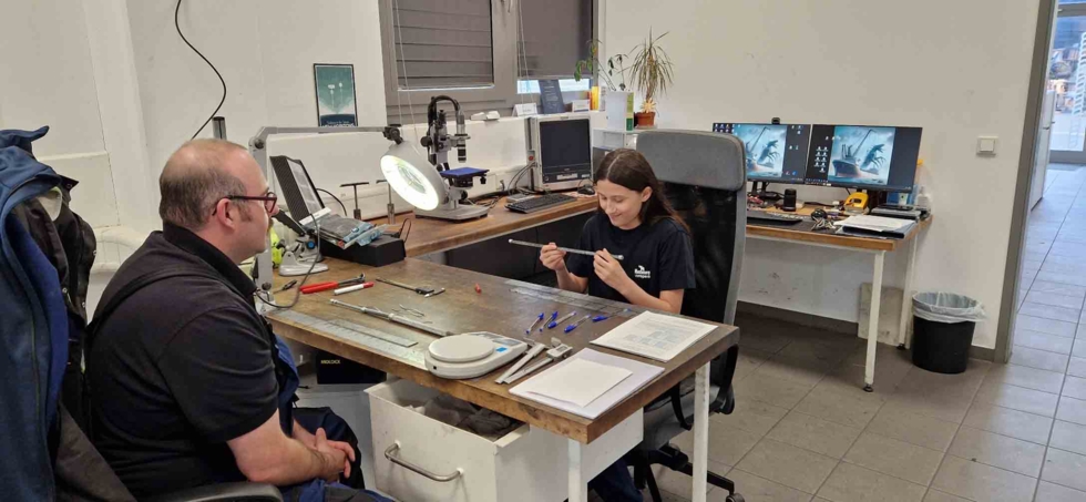 Girls'Day-Teilnehmerin mit Mitarbeiter an der Werkbank