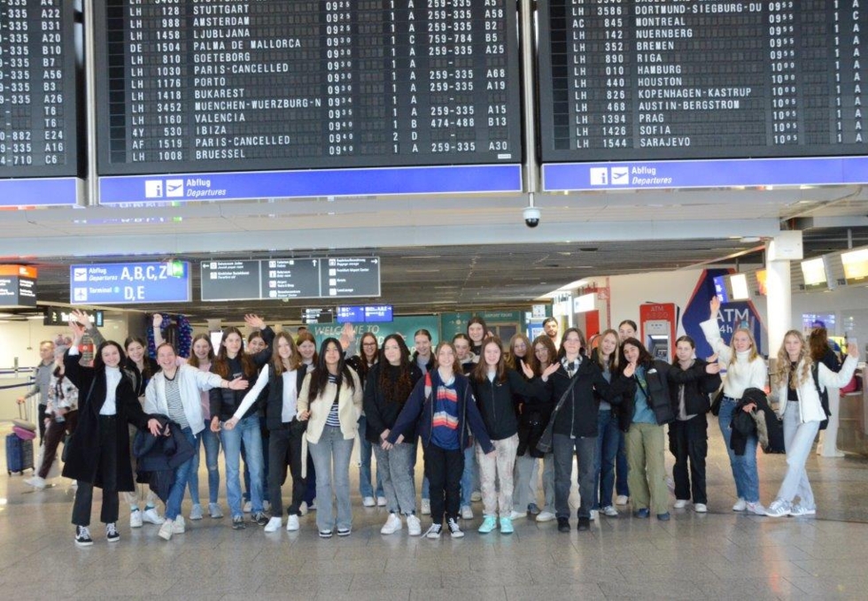 Gruppenbild mit Girls'Day-Teilnehmerinnen vor Abflugtafel