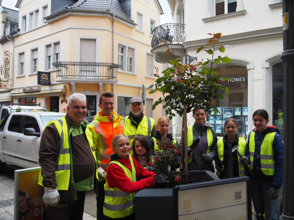 Girls'Day-Teilnehmerinnen mit Gärtnern an Blumenkübeln