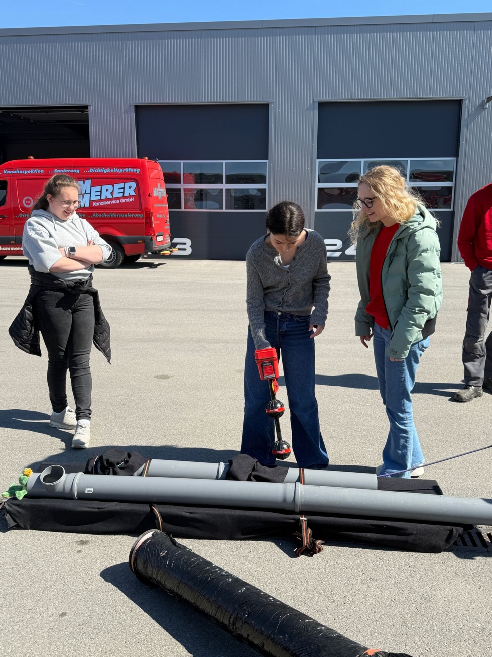 Girls'Day-Teilnehmerinnen mit Kanalrohren