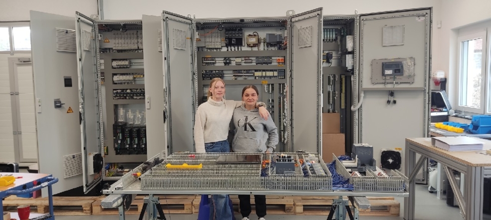Girls'Day-Teilnehmerinnen vor Materialien in der Werkstatt