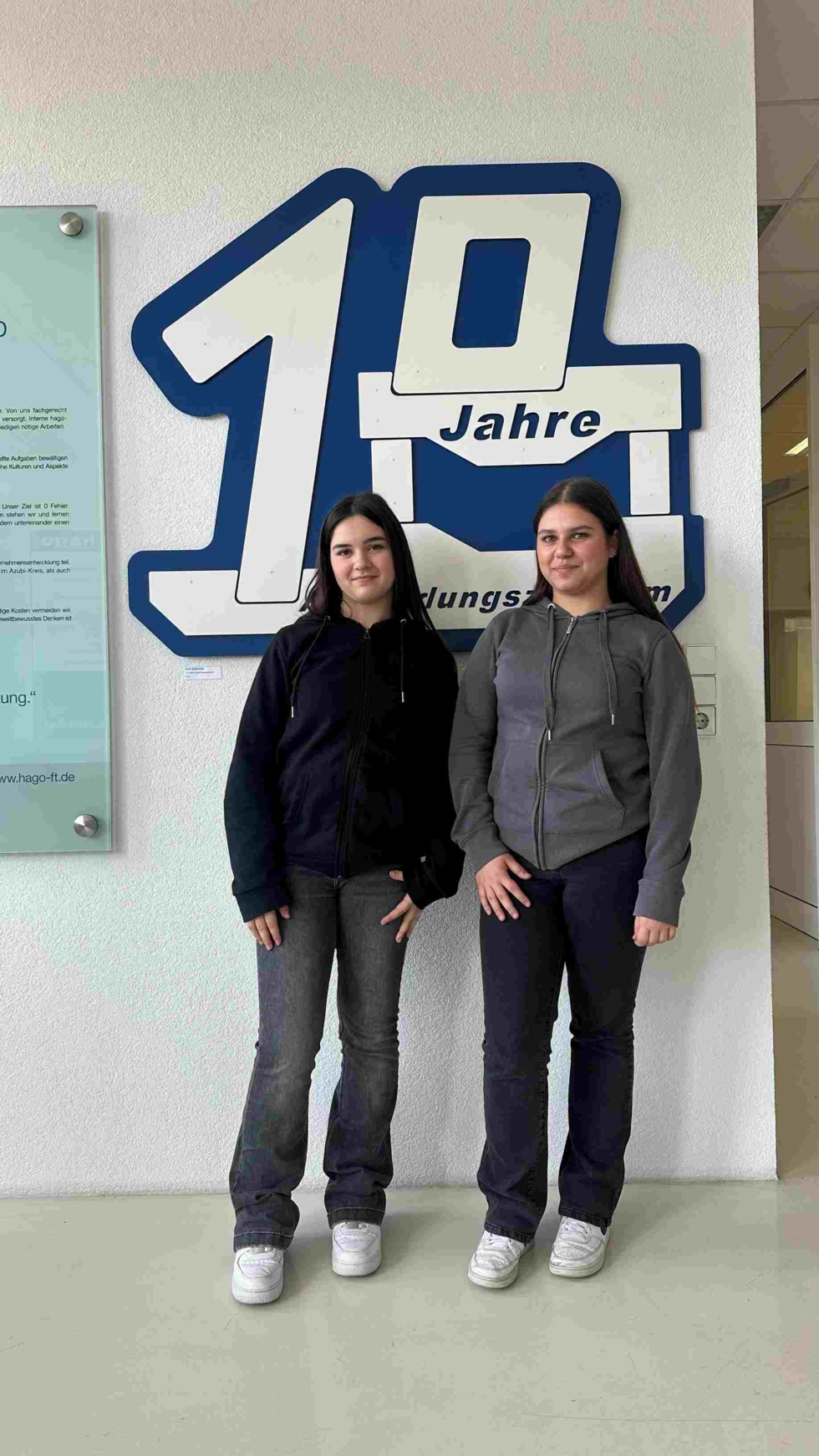 2 Girls'Day-Teilnehmerinnen vor Firmenlogo