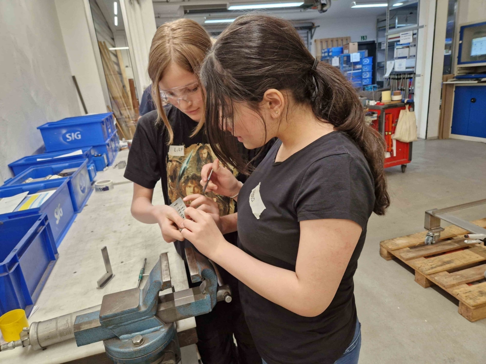 Girls'Day-Teilnehmerinnen werken an Werkbank