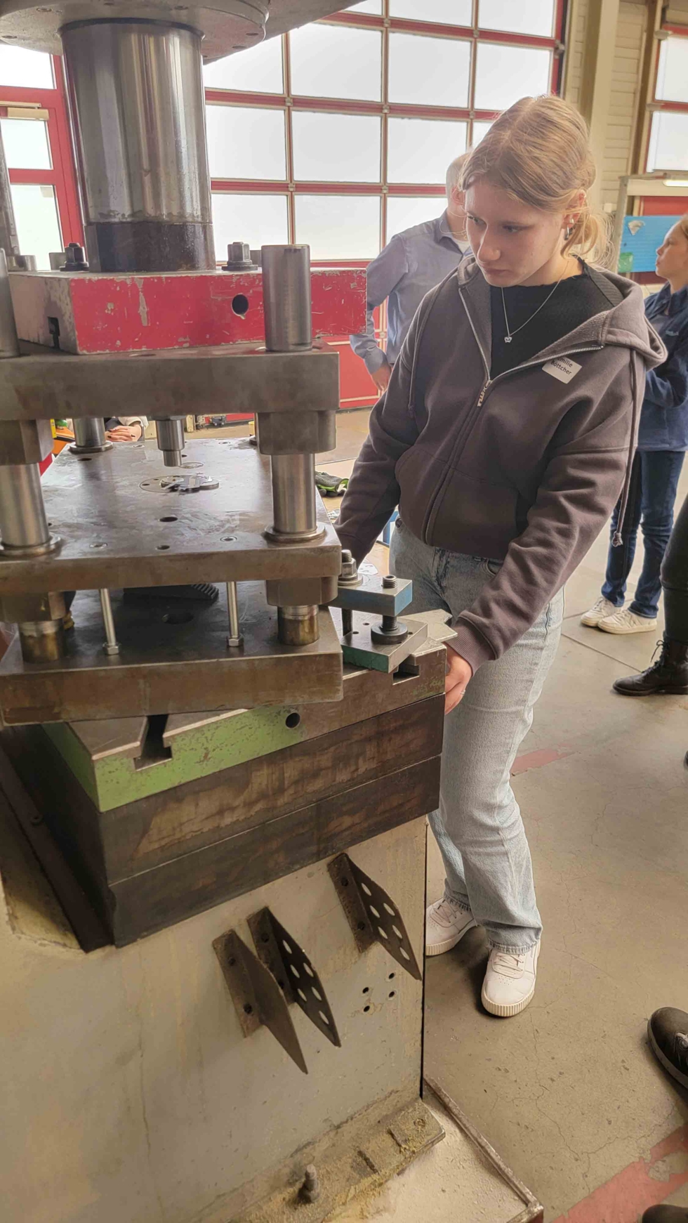 Girls'Day-Teilnehmerin an Stanzmaschine