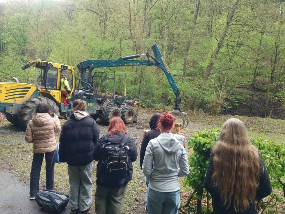 Girls'Day Teilnehmerinnen im Wald vor einem Bagger