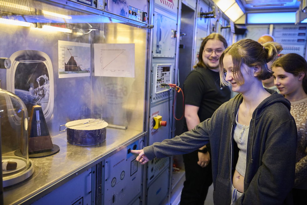 Mädchen machen ein Experiment mit einem Schokokuss in einer Vakuumglocke.