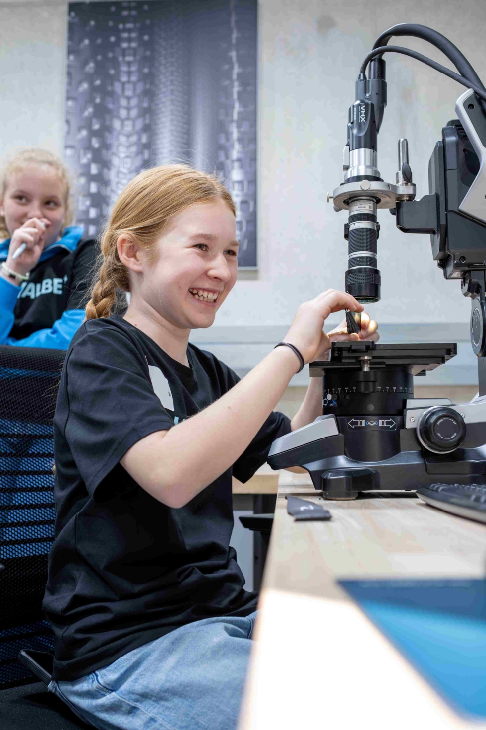 Girls'Day-Teilnehmerinnen an einem Mikroskop