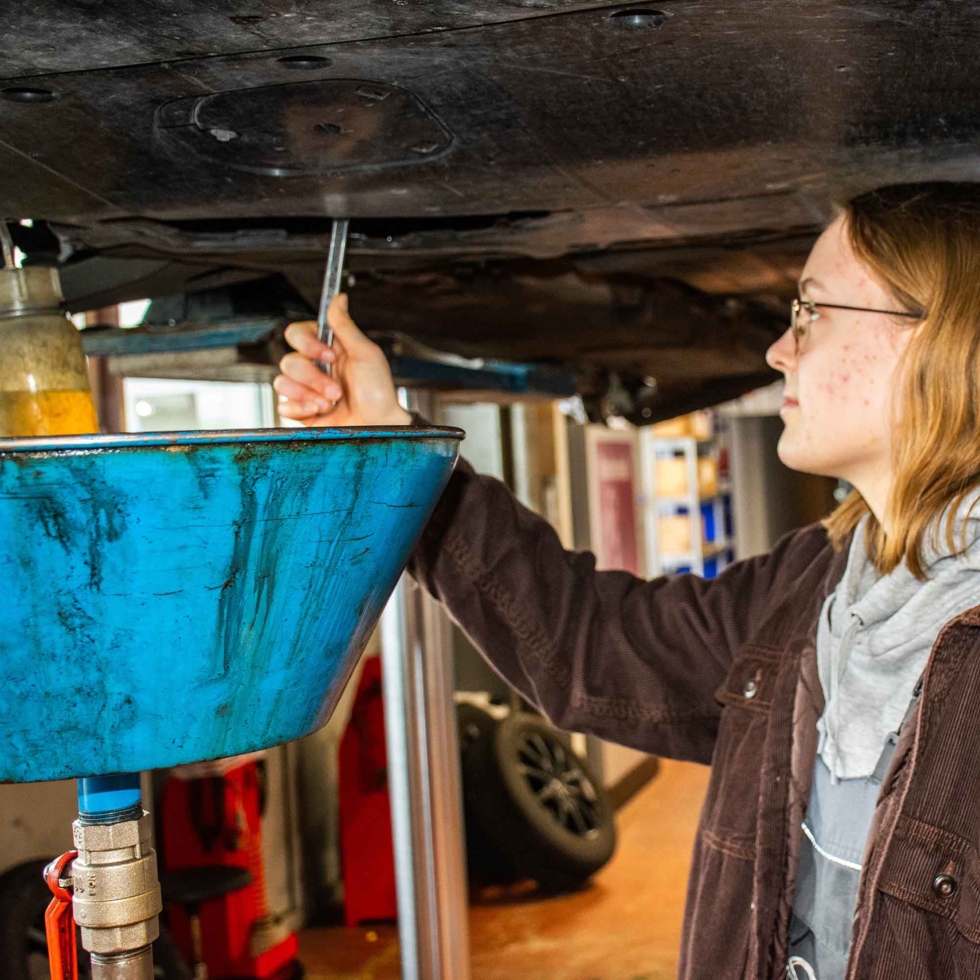 Girls'Day Teilnehmerin prüft den Unterboden des Autos