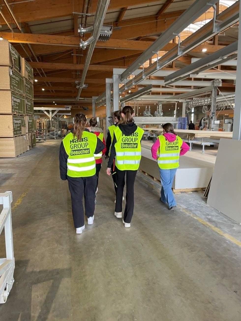 Girls'Day-Teilnehmerinnen mit Warnwesten beim Gang durch die Werkhalle