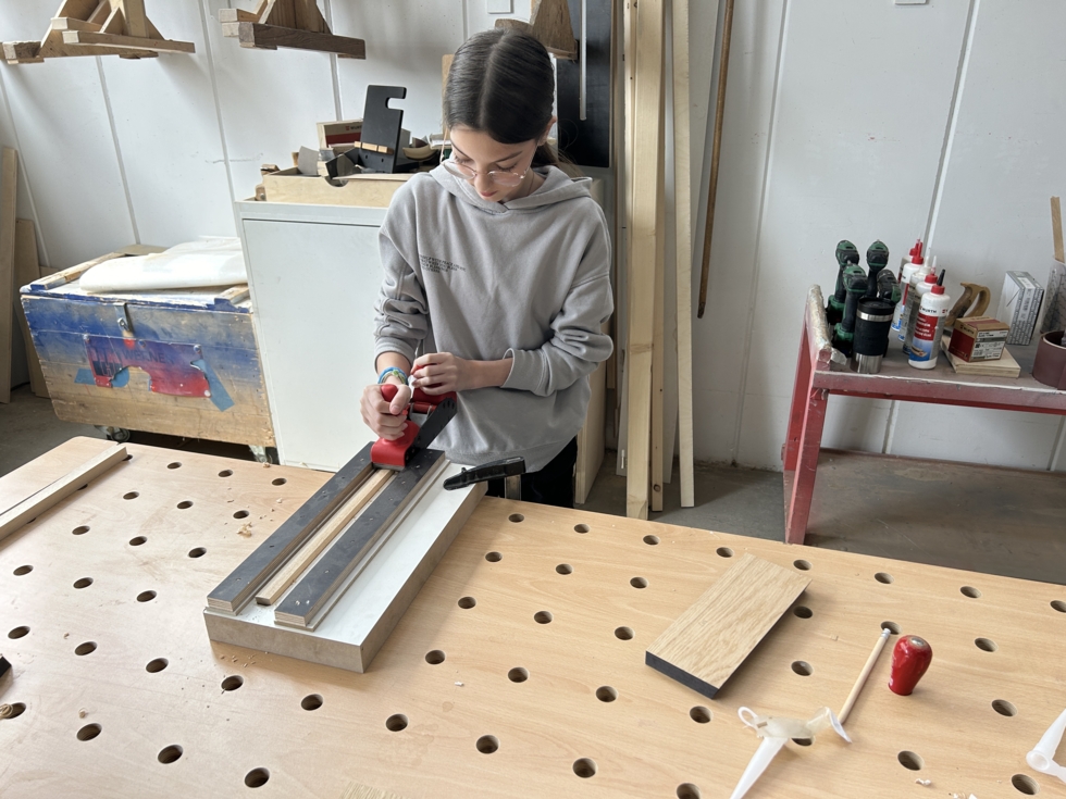 Mädchen an einer Werkbank mit Hobel.