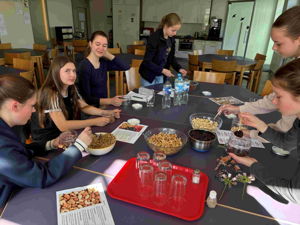 Girls'Day-Teilnehmerinnen bereiten sich an einem Tisch Frühstück zu