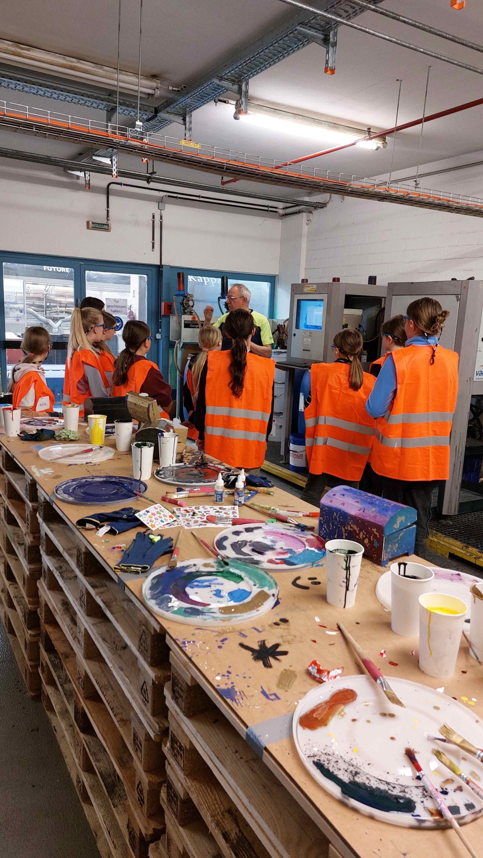 Girls'Day-Teilnehmerinnen in Werkstatt mit Pinseln und Farben