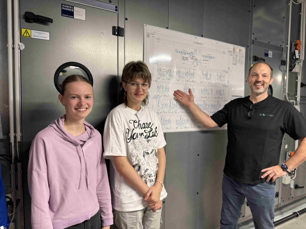 Girls'Day-Teilnehmerinnen mit Mitarbeiter vor Plan