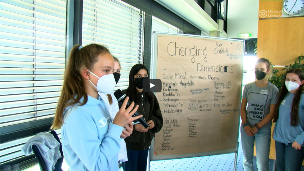 Mädchen mit Masken vor einem Flipchart