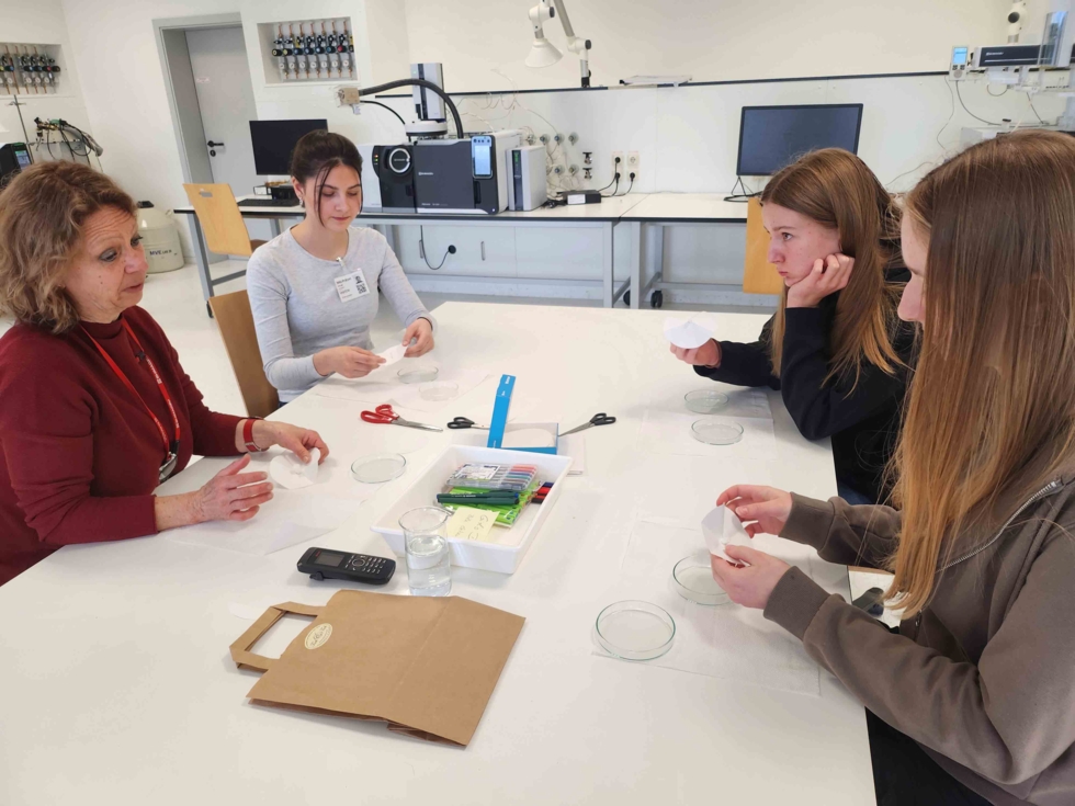 Girls'Day-Teilnehmerinnen beim Experimentieren am Tisch