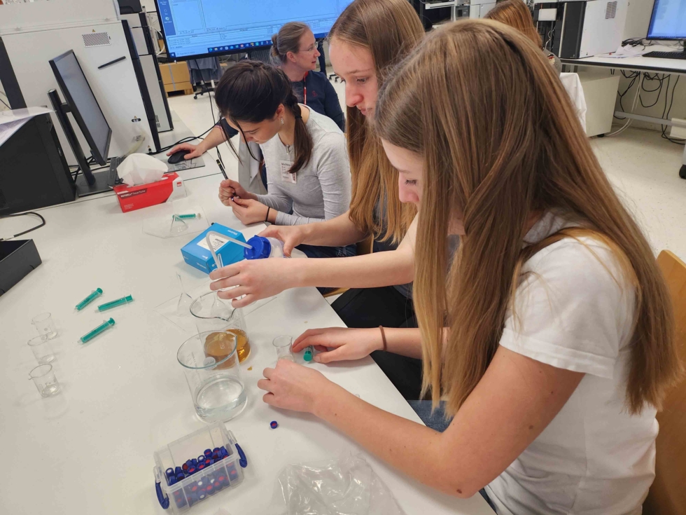 Girls'Day-Teilnehmerinnen beim Experimentieren am Tisch