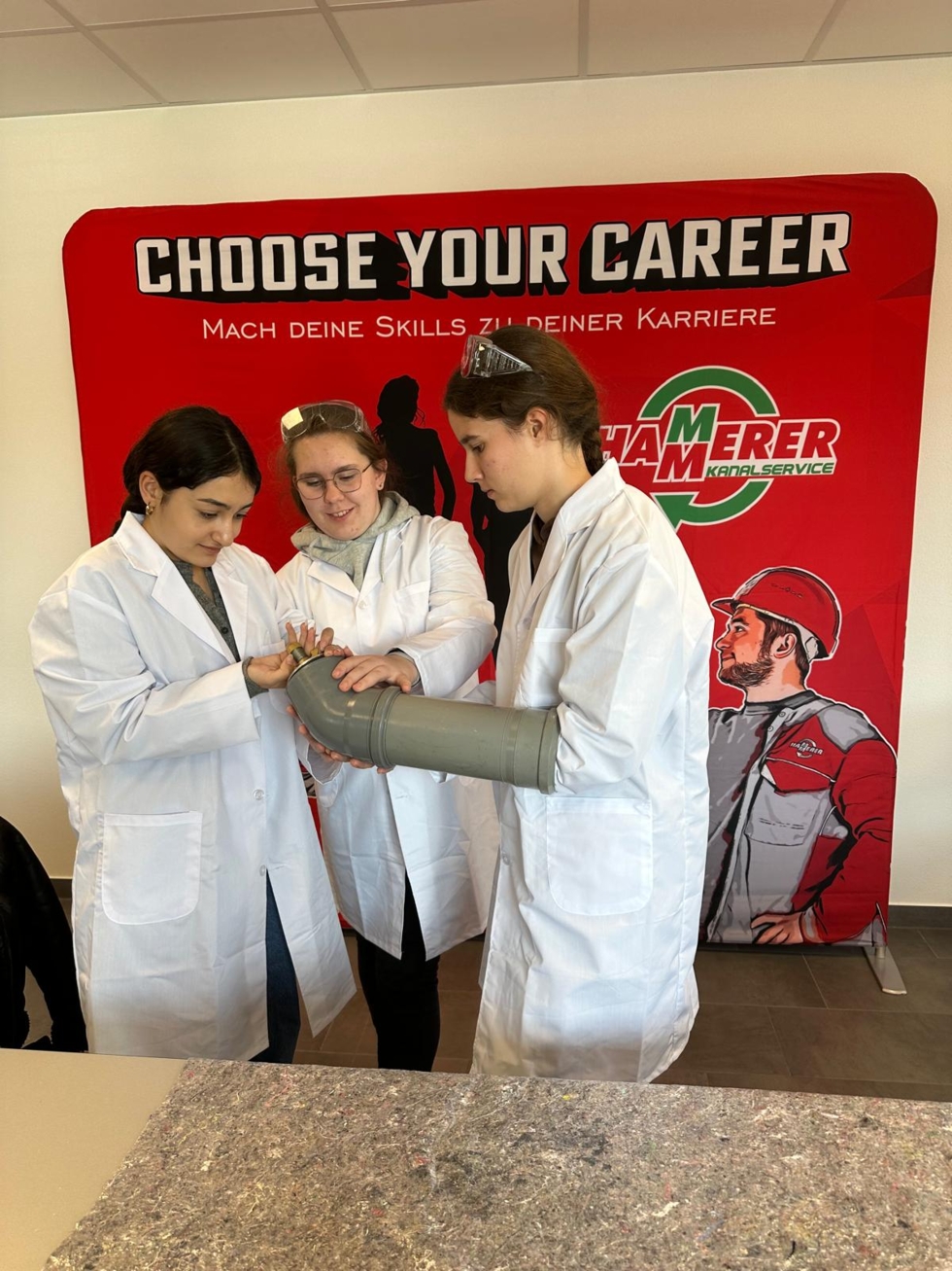 Girls'Day-Teilnehmerinnen mit Kanalrohr