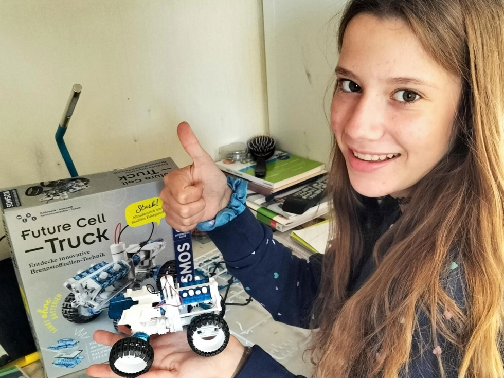 Mädchen mit einem Truck, der aus Bauteilen zusammengebaut wurde