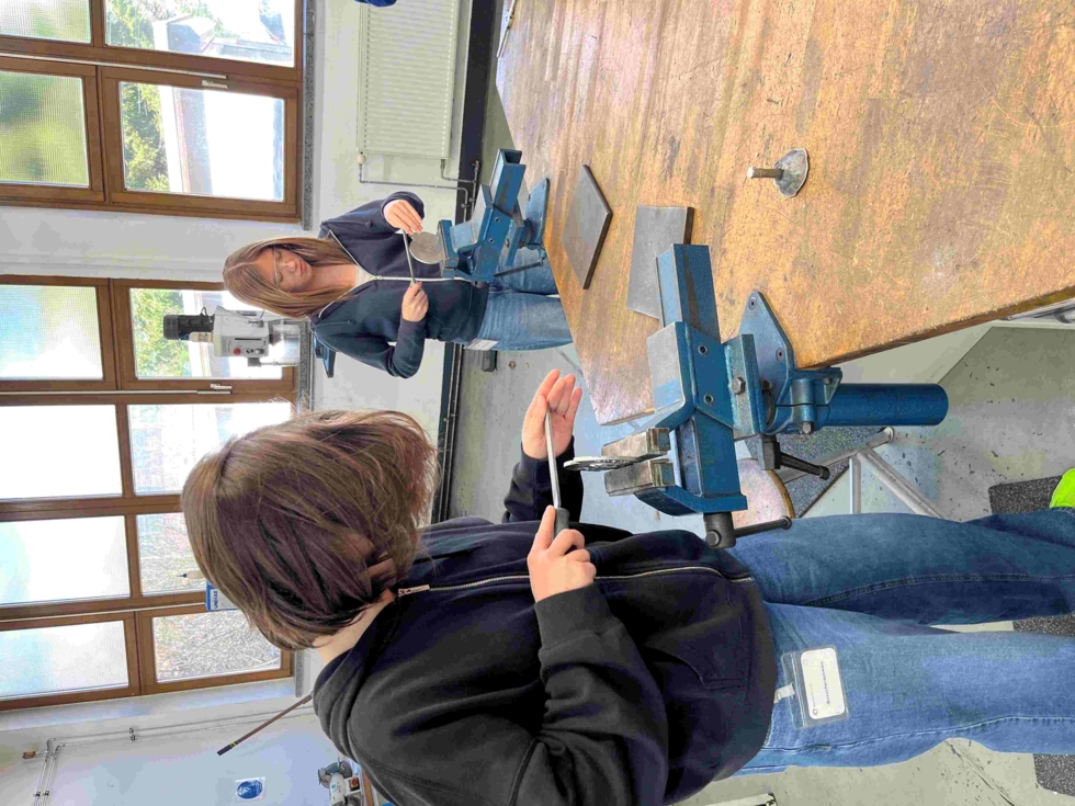 Zwei Girls' Day-Teilnehmerinnen bauen eine Guss Plakette