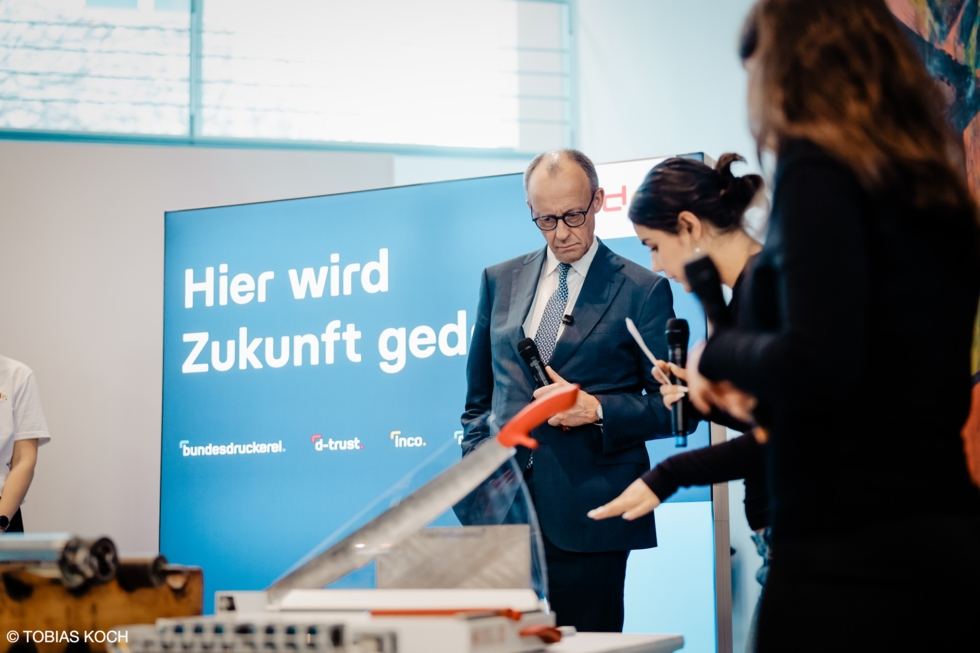 Bundeskanzler Merz mit Girls'Day-Teilnehmerinnen am Stand der Bundesdruckerei